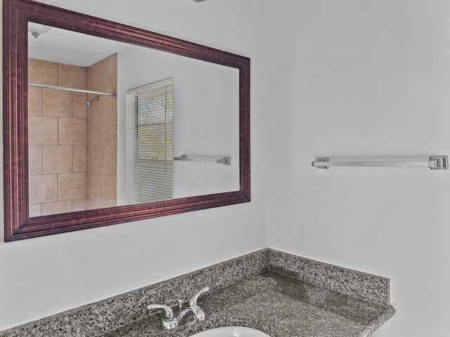 bathroom with sink and a tile shower