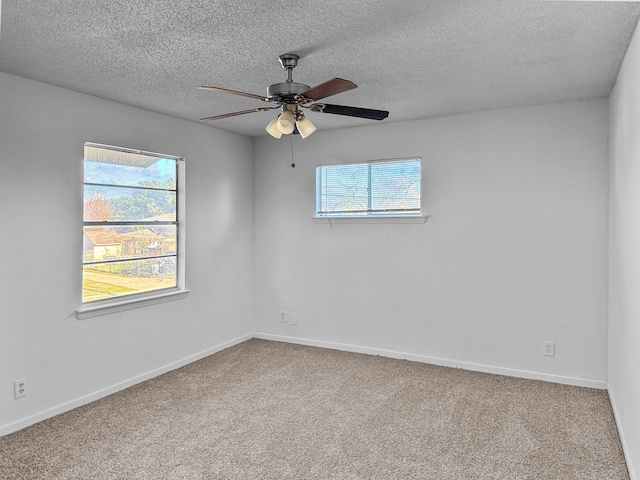 carpeted spare room with a textured ceiling and ceiling fan