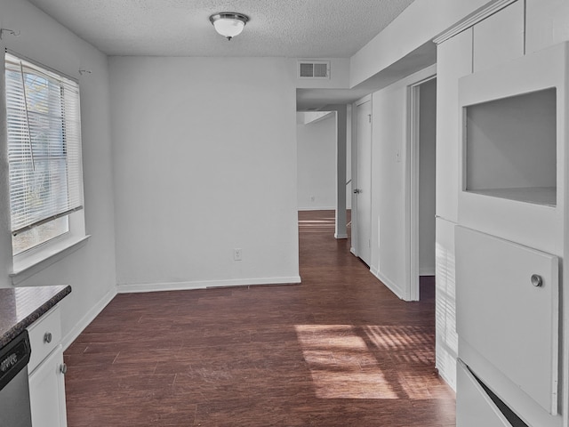 interior space with a textured ceiling, dark hardwood / wood-style floors, and plenty of natural light