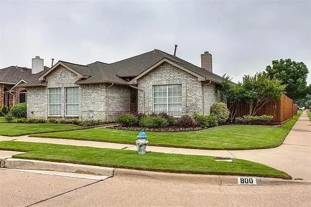 single story home featuring a front lawn