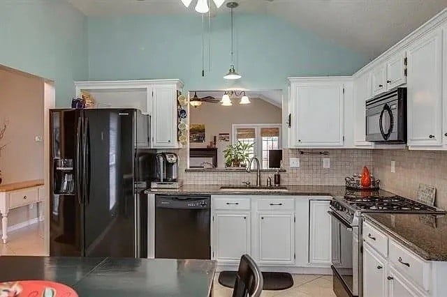 kitchen with black appliances, white cabinets, sink, and pendant lighting