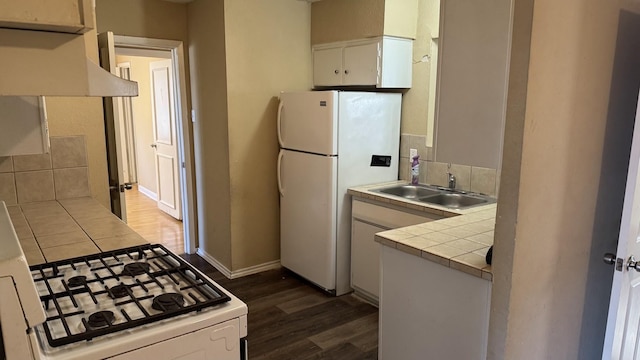 kitchen with sink, white cabinetry, tile countertops, white appliances, and tasteful backsplash