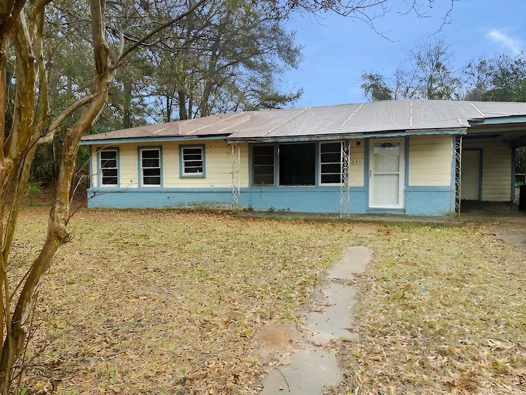 ranch-style house with a carport and a front yard