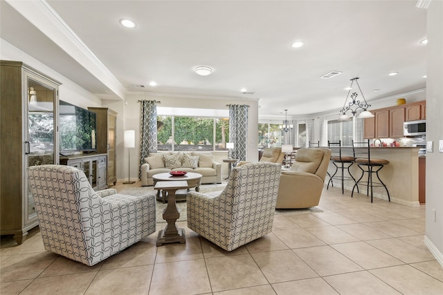 living room with ornamental molding, a notable chandelier, and light tile patterned flooring