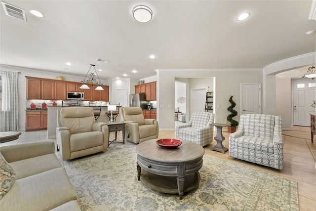 tiled living room featuring a notable chandelier and crown molding