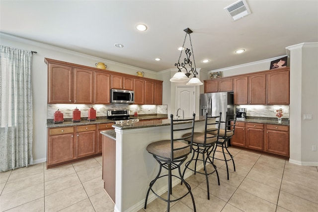 kitchen featuring stainless steel appliances, a center island with sink, a kitchen breakfast bar, and light tile patterned floors