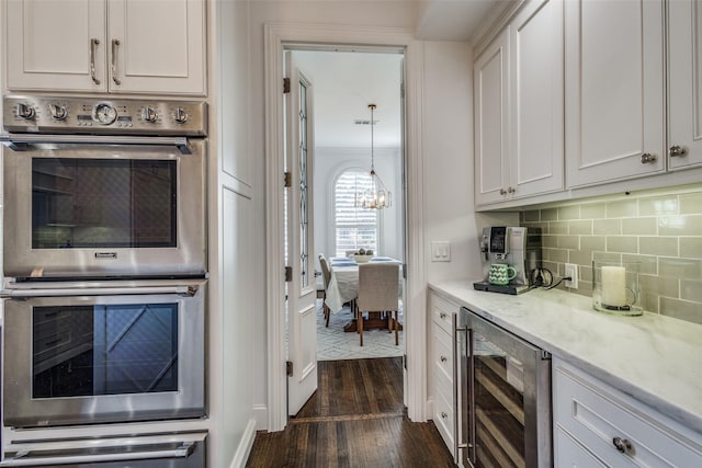 kitchen featuring double oven, white cabinetry, dark hardwood / wood-style floors, and wine cooler