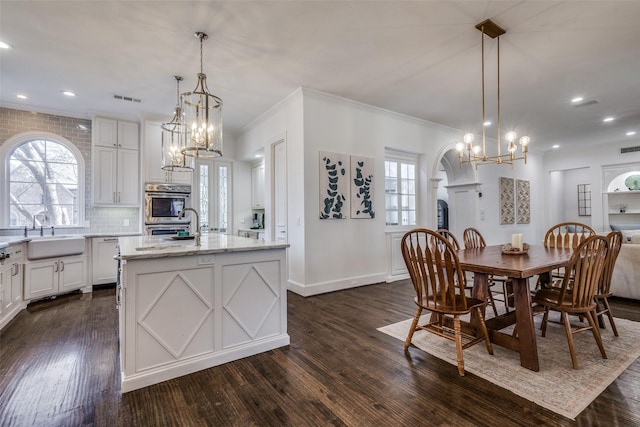 dining space with sink, dark hardwood / wood-style flooring, and plenty of natural light