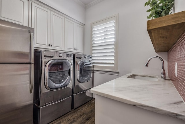 laundry area featuring sink, washing machine and dryer, a healthy amount of sunlight, and cabinets