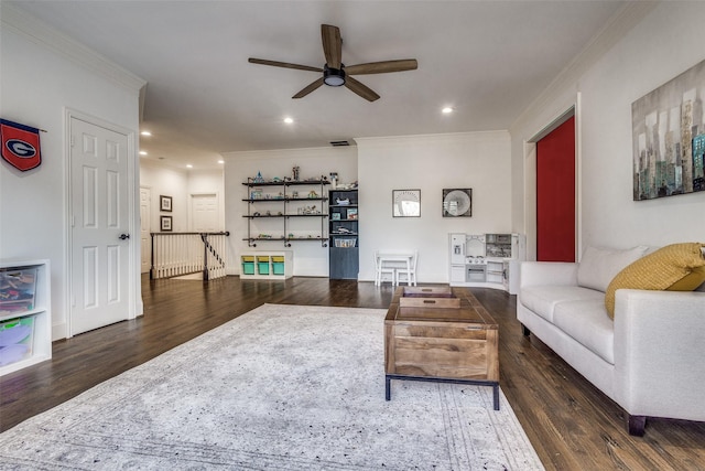 living room featuring ceiling fan, ornamental molding, and dark wood-type flooring