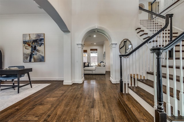 foyer with ornamental molding and dark hardwood / wood-style floors