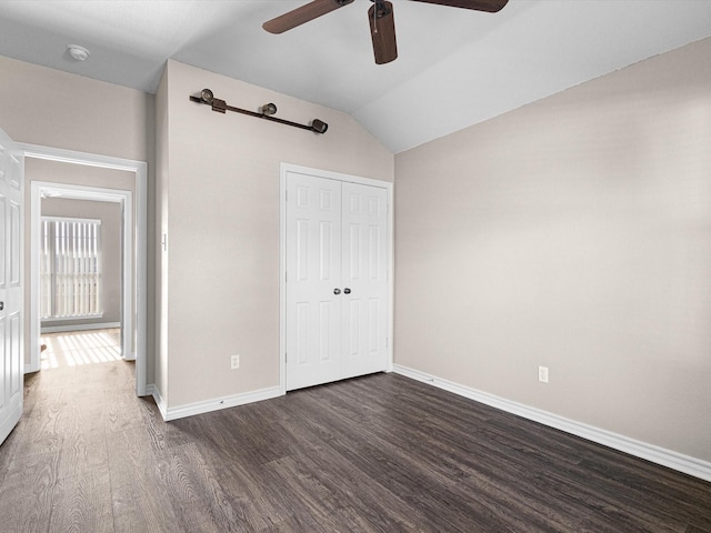 unfurnished bedroom featuring ceiling fan, lofted ceiling, dark hardwood / wood-style flooring, and a closet