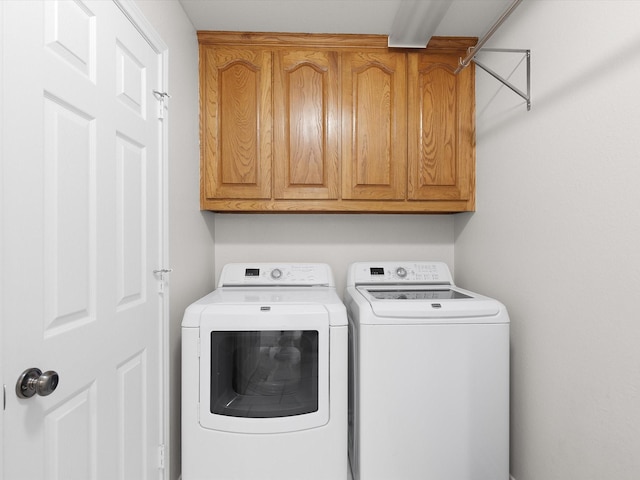 clothes washing area featuring cabinets and independent washer and dryer