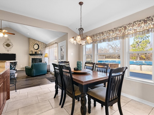 tiled dining area featuring lofted ceiling, a wealth of natural light, and a fireplace