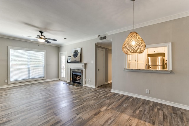 unfurnished living room with ceiling fan, dark hardwood / wood-style flooring, and ornamental molding