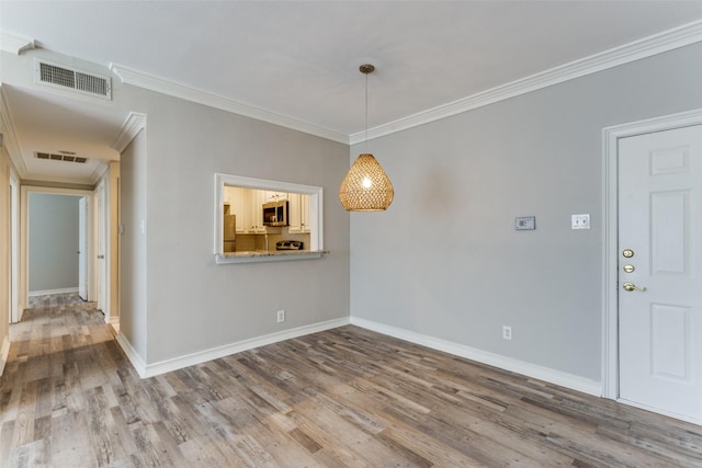 unfurnished dining area with hardwood / wood-style floors and crown molding