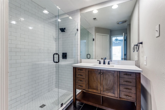 bathroom with a shower with door, vanity, and tile patterned floors