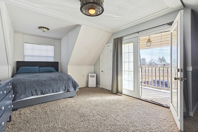 bedroom with multiple windows, carpet, lofted ceiling, and a textured ceiling