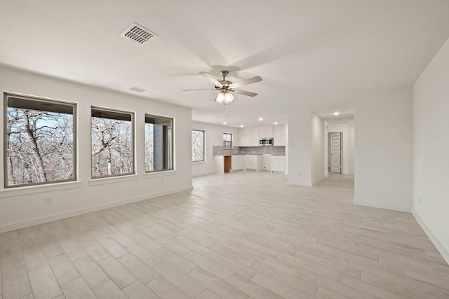 unfurnished living room featuring light wood-type flooring and ceiling fan