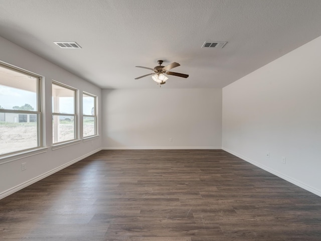 spare room with ceiling fan, a textured ceiling, and dark hardwood / wood-style floors