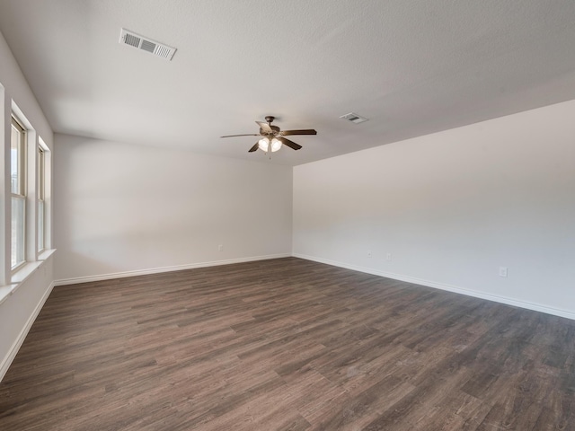 unfurnished room with ceiling fan, dark hardwood / wood-style flooring, and a textured ceiling