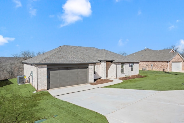 ranch-style house featuring a garage, central AC unit, and a front yard