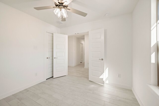 empty room with ceiling fan and light wood-type flooring