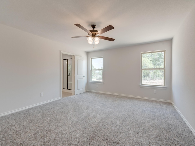 carpeted empty room featuring ceiling fan and a wealth of natural light