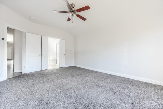 unfurnished bedroom with lofted ceiling, ceiling fan, carpet flooring, and connected bathroom