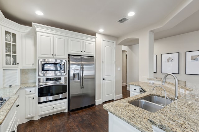 kitchen featuring stainless steel appliances, white cabinets, and light stone countertops