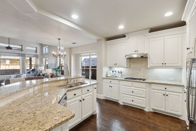 kitchen featuring white cabinetry, dark hardwood / wood-style floors, decorative light fixtures, light stone countertops, and sink