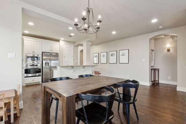 dining area featuring dark wood-type flooring and a notable chandelier