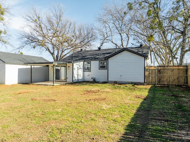 back of property with a patio area and a lawn