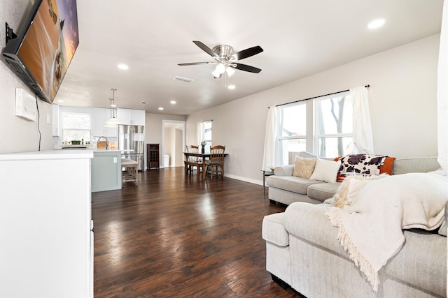 living room with ceiling fan, sink, and dark hardwood / wood-style floors