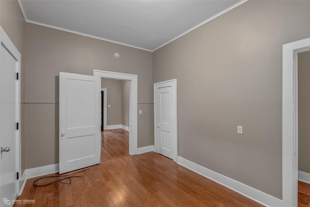 unfurnished bedroom with crown molding and light hardwood / wood-style flooring