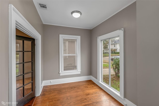 empty room featuring light hardwood / wood-style floors and crown molding