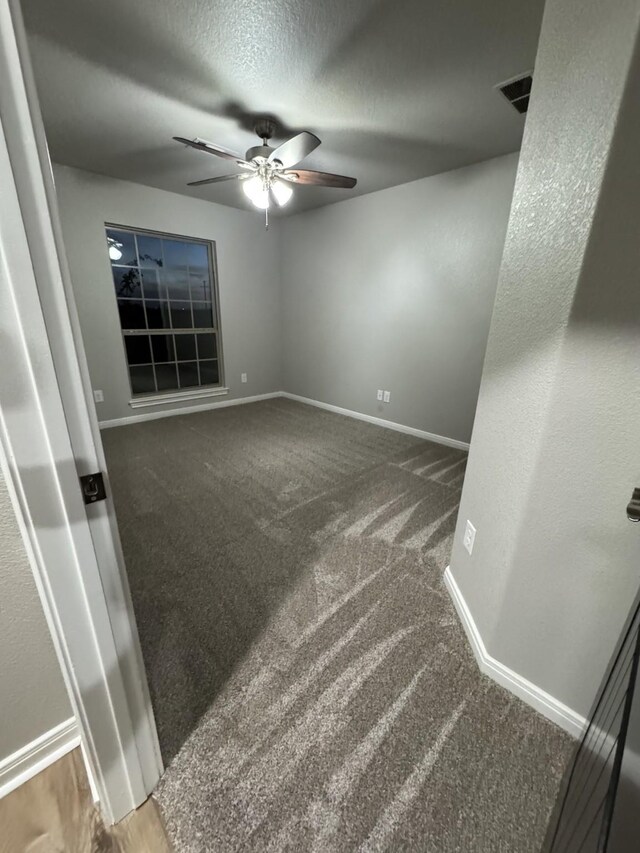 unfurnished room featuring a textured ceiling, carpet floors, and ceiling fan