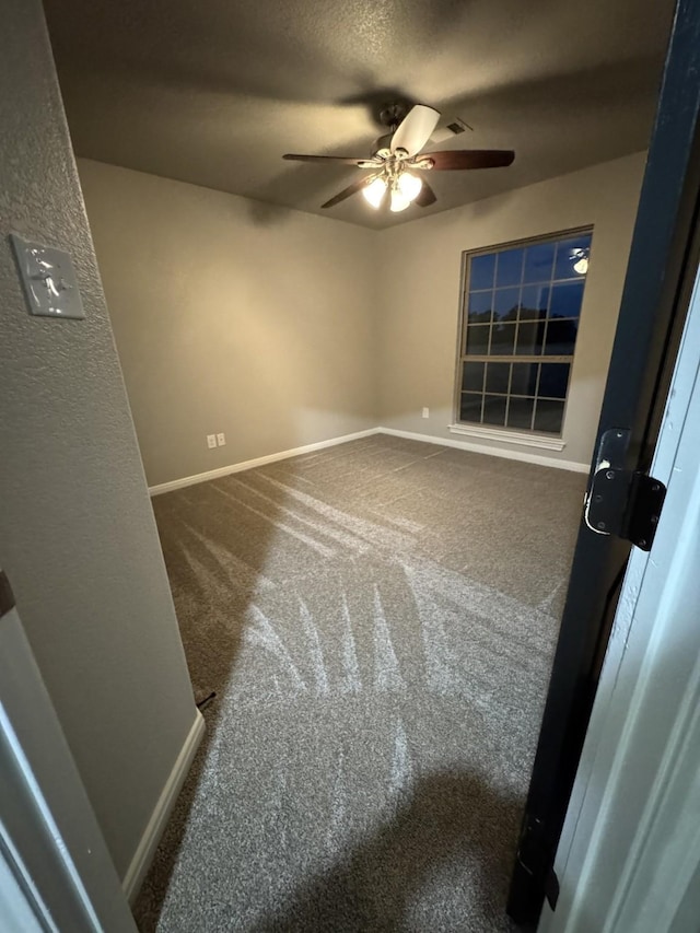 unfurnished room with a textured ceiling, ceiling fan, and carpet