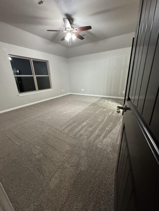 unfurnished room featuring carpet flooring, a textured ceiling, and ceiling fan