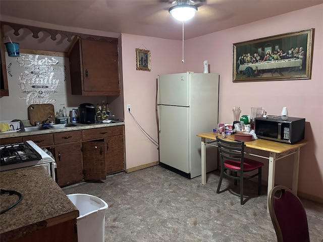 kitchen featuring sink, white appliances, ceiling fan, and dark brown cabinetry