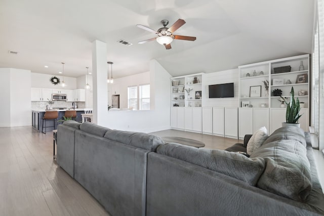 living room with ceiling fan and light hardwood / wood-style floors