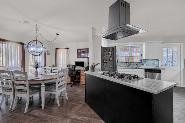 kitchen with decorative light fixtures, white cabinets, island exhaust hood, a chandelier, and appliances with stainless steel finishes