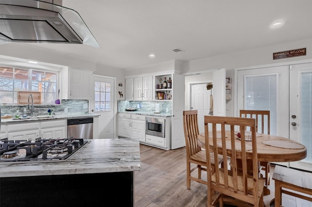 kitchen featuring stainless steel appliances, sink, white cabinets, tasteful backsplash, and a kitchen island