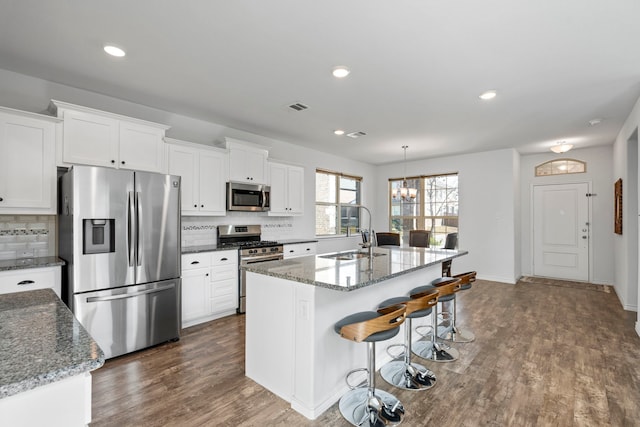 kitchen featuring stainless steel appliances, a kitchen island with sink, white cabinets, and sink