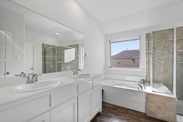 bathroom with vaulted ceiling, separate shower and tub, wood-type flooring, and vanity