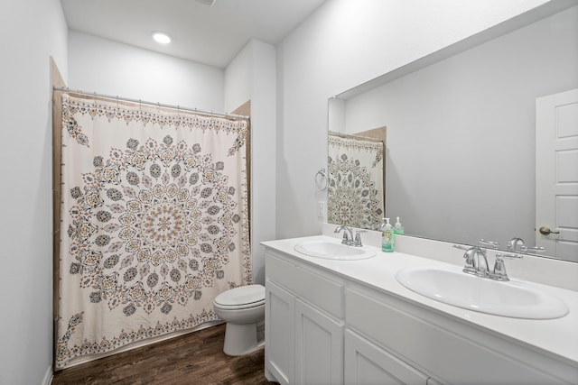 bathroom featuring a shower with shower curtain, hardwood / wood-style floors, vanity, and toilet