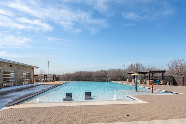 view of swimming pool with pool water feature, a pergola, and a patio