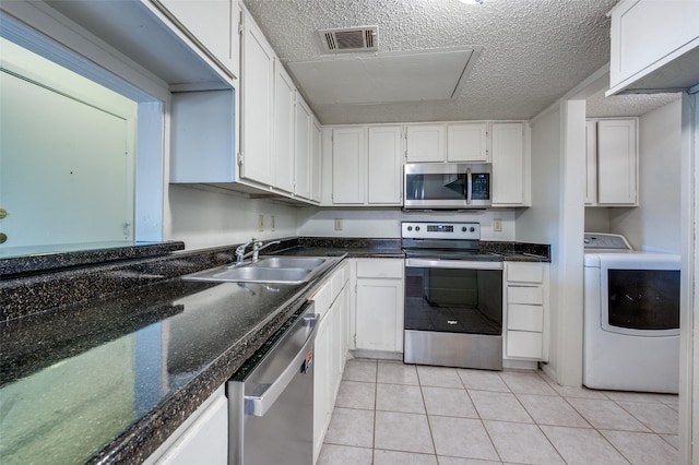 kitchen with a textured ceiling, white cabinetry, washer / clothes dryer, appliances with stainless steel finishes, and sink