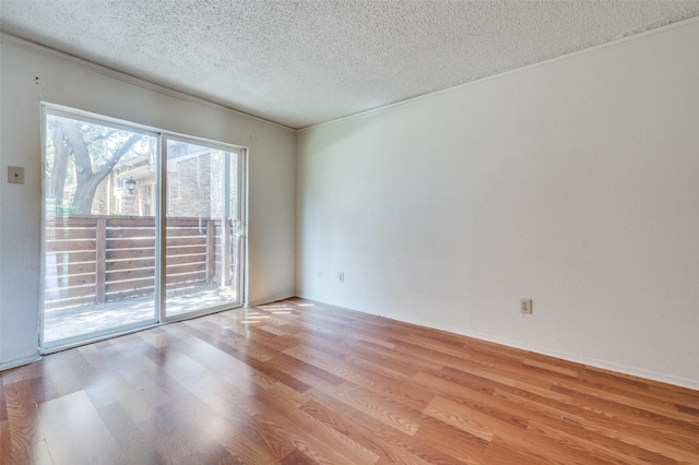 spare room featuring crown molding, a textured ceiling, and light hardwood / wood-style flooring