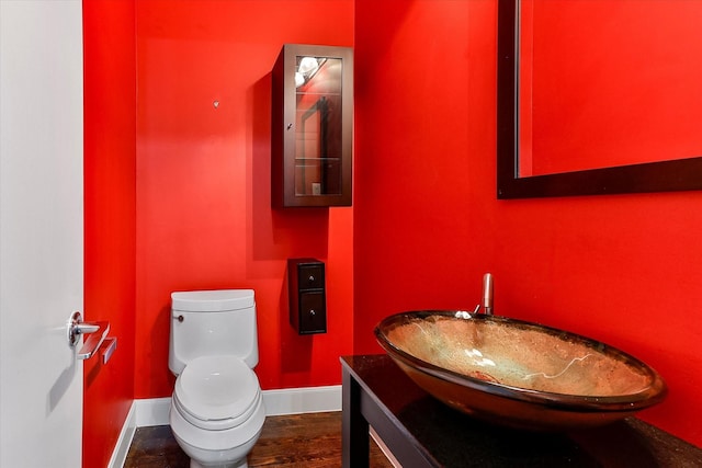 bathroom with hardwood / wood-style floors, vanity, and toilet